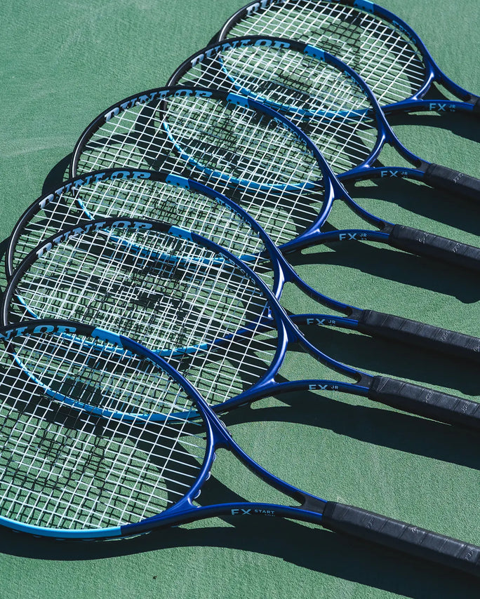 Multiple blue tennis rackets on a green surface