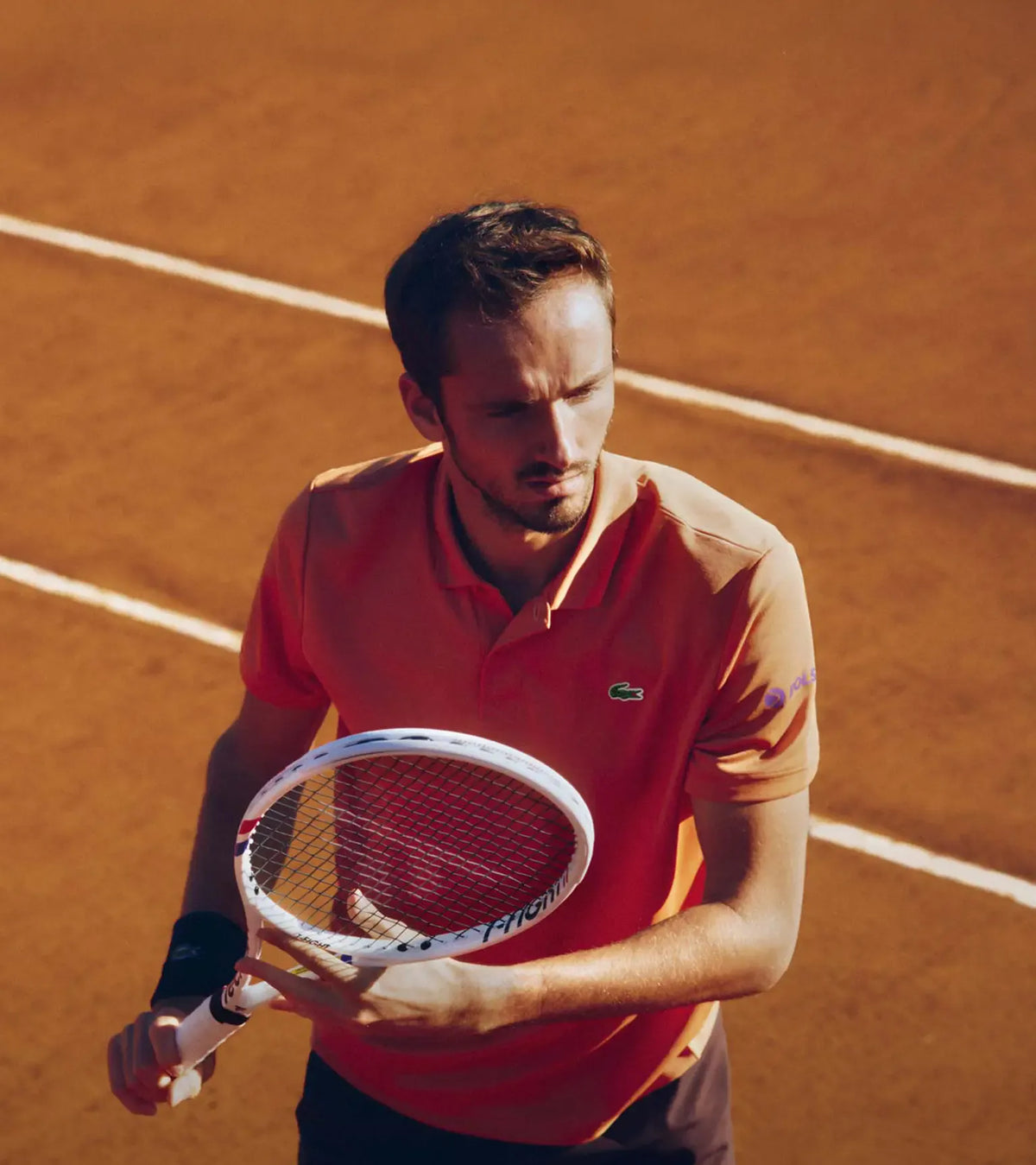 Man holding a tennis racket on a clay court